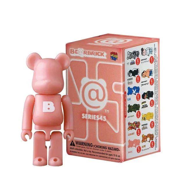 Pink 100% Bearbrick Blindbox Series 45 figure standing next to its box featuring multiple design options and warnings.